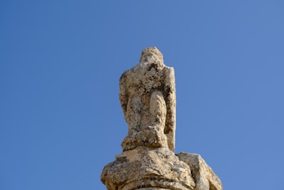 A stone sculpture stands against a blue sky.